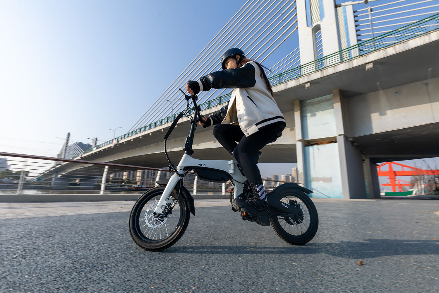 Urban commuter enjoying affordable electric bike ride across modern city bridge showcasing practical daily transportation benefits.