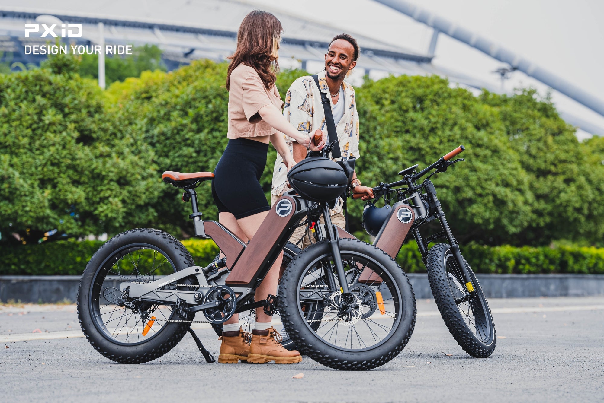Couple enjoying modern electric mountain bike together in urban park setting with scenic bridge background view.